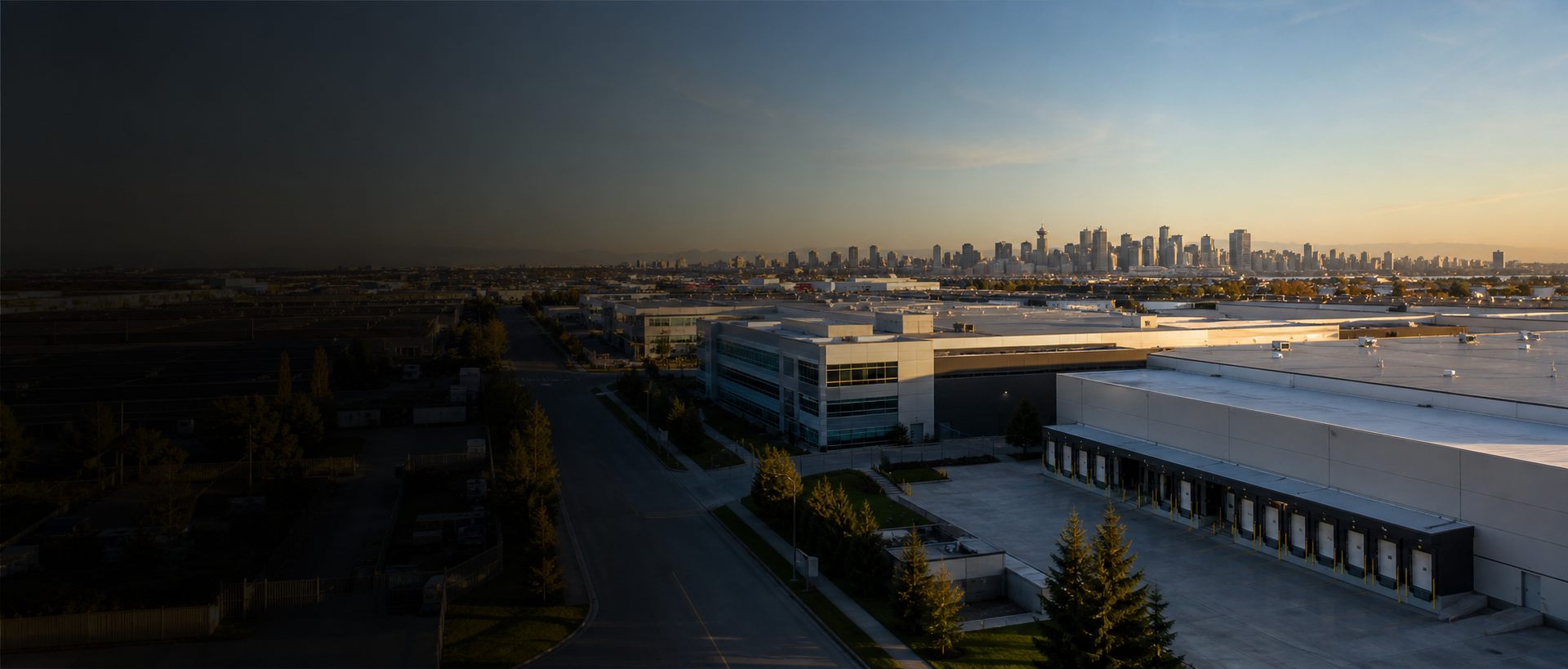 Industrial warehouses and commercial real estate near a city skyline